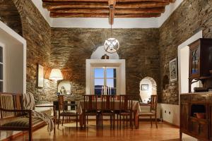 a dining room with a stone wall and a table and chairs at Astra Residential Apts in Korthi