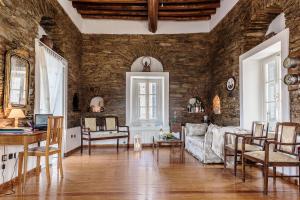 a living room with a stone wall at Astra, Pyrgos Sareli 1690 - a Heritage Mansion in Korthi +146 photos