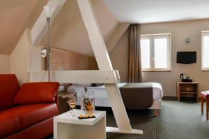 a room with a bed and a living room with a couch at La Clef des Champs - Proche Colmar in Biesheim