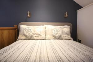 a bedroom with a bed with white sheets and pillows at The Well house in Ilfracombe