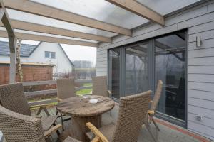 a patio with a wooden table and chairs at Familie Carstensen in Janneby