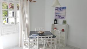 ein Esszimmer mit einem Tisch, Stühlen und einem Fenster in der Unterkunft La Concha del Mar in Corralejo