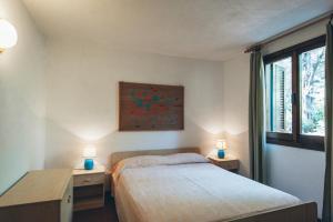 sypialnia z łóżkiem i dwoma stołami z lampkami w obiekcie Residence Portorotondo Tre w mieście Porto Rotondo