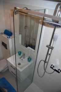 W łazience znajduje się prysznic i umywalka. w obiekcie Apartament Kamienna w mieście Gdynia