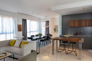 a living room and kitchen with a couch and a table at Herods Herzliya in Herzliya