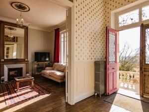 a living room with a couch and a fireplace and a door at Mansion with Private Pool in Aquitaine in Savignac-Lédrier