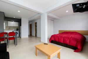 een slaapkamer met een rood bed en een tafel bij Infinity II Apartamentos in Ushuaia