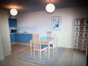 a kitchen with a table and chairs and blue cabinets at Beach Front Apt Portballintrae , Bushmills close to Royal Portrush Golf Club in Portballintrae
