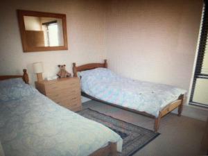 a bedroom with two twin beds and a mirror at Beach Front Apt Portballintrae , Bushmills close to Royal Portrush Golf Club in Portballintrae