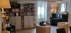 un salon avec une étagère remplie de livres dans l'établissement Le Clos de la Vigne, à Montreuil