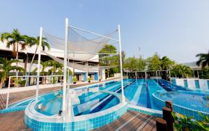 una piscina en un complejo con azulejos azules en Kocchira en Hua Hin
