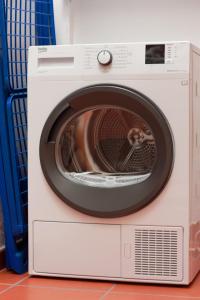 a white washing machine with its door open at Hostel Nature in Zambujeira do Mar