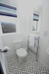 a white bathroom with a toilet and a sink at Apartment 3 Broadhurst Court sleeps 4 minutes from town centre & train in Stockport