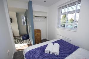 um quarto com uma cama com duas toalhas em Apartment 3 Broadhurst Court sleeps 4 minutes from town centre & train em Stockport