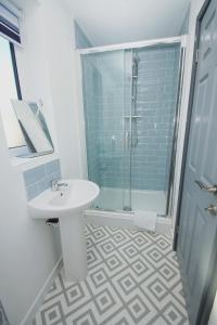 Un baño con lavabo y ducha de cristal. en Apartment 3 Broadhurst Court sleeps 4 minutes from town centre & train, en Stockport