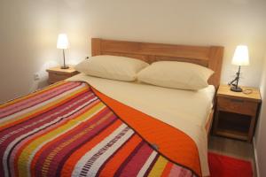 a bedroom with a bed with a colorful blanket on it at Apartments Toni Sea view in Primošten