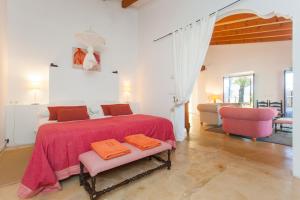 a bedroom with a large bed with a pink blanket at Oliver Moragues Grandhouse & Vineyard in Algaida