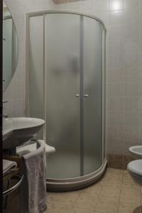 una doccia con porta in vetro in bagno di Hotel Beatrice a Este
