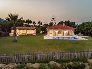 a house with a large yard with a fence at Zante Vista Villas in Lithakia