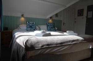 a bed with white sheets and pillows in a bedroom at Tregenna Guest House in Falmouth