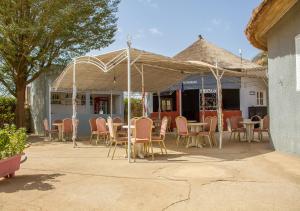 a patio with chairs and tables under a tent at Melia Hotel in Saly Portudal
