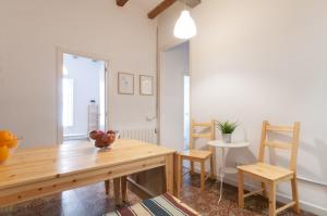 uma sala de jantar com uma mesa de madeira e cadeiras em Gopal-Comfortable Cozy Apartment for Groups in Gracia em Barcelona