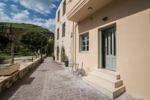 - un bâtiment avec des escaliers et des chaises à côté d'une rue dans l'établissement Cretan Berry Portou, à La Canée
