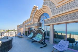 a balcony with chairs and a couch on a building at Hometown Apartments - Kite Palace - Lavish 7 Bedrooms villa on Kite Beach in Dubai