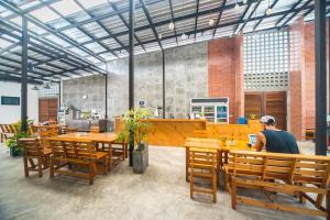 a man sitting at a table in a restaurant at ChillHub Hostel Phuket in Bang Tao Beach