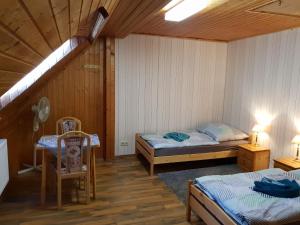 a room with two beds and a table and chairs at Dudu's Gästehaus in Diebach am Haag