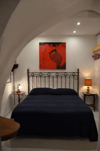 una camera da letto con un letto nero e un dipinto sul muro di Il Cuore di Amalfi ad Amalfi