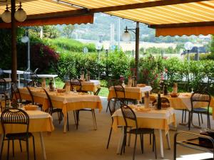 ein Restaurant mit Tischen und Stühlen mit gelben Tischdecken in der Unterkunft Albergo Villa Eva in Costermano sul Garda