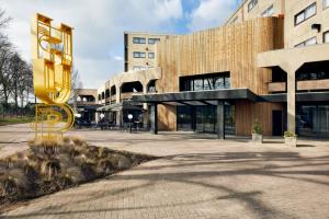 a building with a large yellow sculpture in front of it at HUP in Mierlo