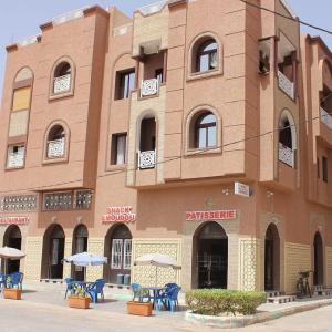 Hotel AMOUDOU فندق أمودو في تزنيت: مبنى امامه كراسي ومظلات