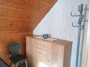 Habitación de madera con silla y cómoda en Dudu's Gästehaus en Diebach am Haag
