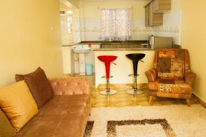 a living room with a couch and a kitchen at Ashville Homes Meru in Meru