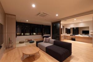 a living room with a couch and a table at Miyajima Hanare no Yado IBUKU in Miyajima