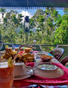 a table with food on it with a view of palm trees at Cozy Homestay Waterfall Road Ella in Ella