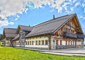 a large wooden building with a roof at Alpska Perla Apartments in Cerkno