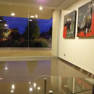 a room with a glass table and paintings on the wall at Apartamento Alemania in Temuco