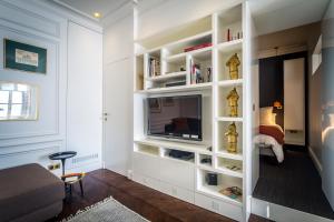 uma sala de estar com uma televisão numa prateleira de livros brancos em L'Appartement des Roches em Metz