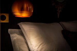 a light hanging over a bed with a white pillow at L'Appartement des Roches in Metz