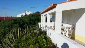 a white house with a table and chairs on the balcony at Casa Jasmin in Aljezur