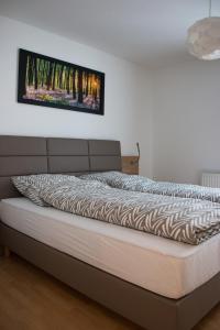łóżko w sypialni z obrazem na ścianie w obiekcie Espelkamp Gästehaus w mieście Espelkamp