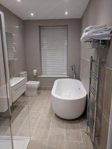 a bathroom with a large tub and a toilet at Lion House Bed & Breakfast with Restaurant in Combe Martin