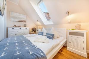 a bedroom with a large white bed with blue sheets at Seebrise in Zingst
