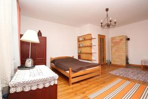 a bedroom with a bed and a table with a lamp at Mazurski dworek przy Jeziorze in Dworackie