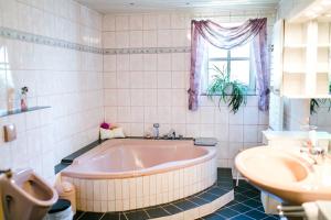 a bathroom with a tub and a sink and a toilet at Hohes Ferienhaus in Heiligenstadt +29 photos