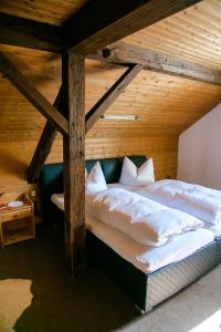Cama grande en habitación con techo de madera en Hohes Ferienhaus, en Heiligenstadt