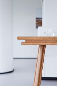 a wooden table with a white refrigerator in the background at Urban Residences Rotterdam in Rotterdam